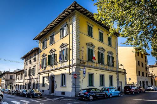 un edificio amarillo con coches estacionados frente a él en Hotel Ferrucci, en Florencia