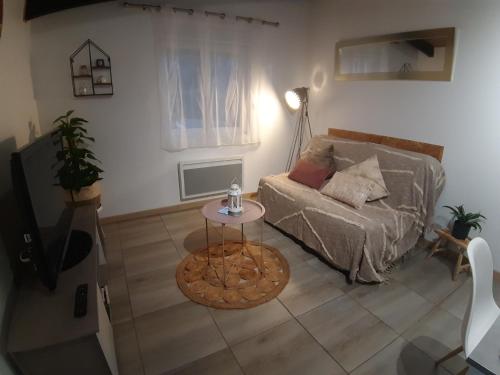 een woonkamer met een bank en een tafel bij Gîte L'Ecureuil*** in MouscardÃ¨s