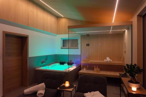 a bathroom with a tub and a room with a couch at Bergzeit Gosau in Gosau