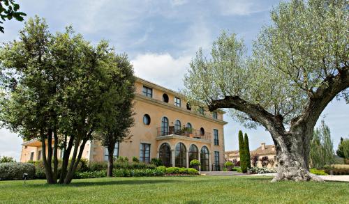 a large building with trees in front of it at Casa Anamaria Hotel in Ollers