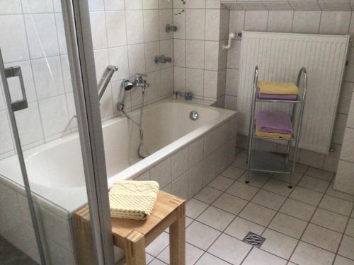 uma casa de banho com uma banheira, um chuveiro e uma mesa em Ferienwohnung im Höfchen em Eckfeld