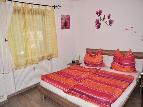 a bedroom with a bed with red pillows on it at Haus am Wiesengrund in Reit im Winkl