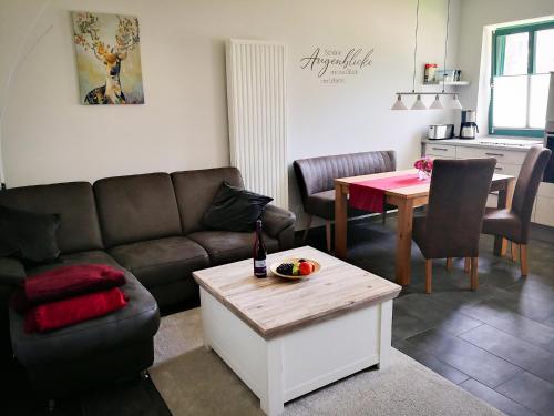 sala de estar con sofá y mesa en Auszeithof Otersen - Ferienwohnung 4, en Kirchlinteln