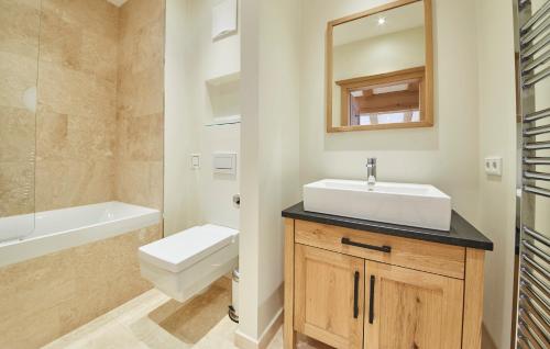 a bathroom with a sink and a toilet and a mirror at Chalet Tannenbaum in Saalbach Hinterglemm