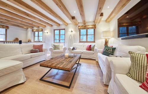 a living room with white furniture and a wooden table at Chalet Tannenbaum in Saalbach Hinterglemm