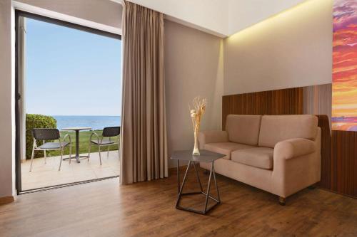 a living room with a couch and a table at Ramada Plaza by Wyndham Thraki in Alexandroupoli