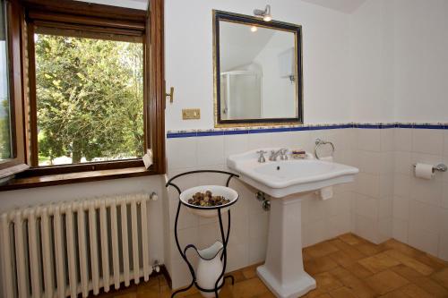 a bathroom with a sink and a mirror and a window at Brigolante Guest Apartments in Assisi