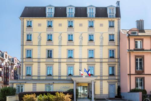 un gran edificio con dos banderas delante en Best Western Plus Hotel Villa D'est, en Estrasburgo