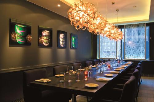 a long table in a restaurant with chairs and a chandelier at Radisson Blu Waterfront Hotel, Stockholm in Stockholm