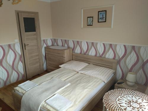 a bedroom with a bed with a striped head board at Karolinka leba - FIRST MINUTE SEZON 2026!!! in Łeba