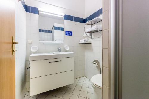 a white bathroom with a sink and a toilet at Stadthotel Raabs an der Thaya in Raabs an der Thaya