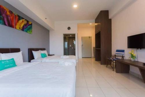 a hotel room with two beds and a television at KK studio [B]/2 Queen Bed/ Netflix/Free Parking in Kota Kinabalu