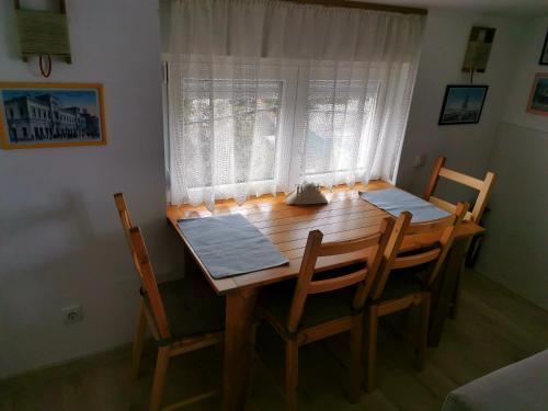 Una mesa de comedor con cuatro sillas y una ventana. en Gardos riverview, en Belgrado