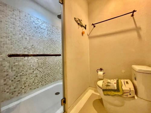 a bathroom with a toilet and a shower and a tub at Chelona huahin beachfront resort condo in Khao Tao