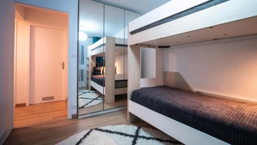 Superbe appartement au coeur du Colmar في كولمار: غرفة نوم مع سرير بطابقين ومرآة