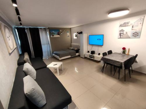 sala de estar con sofá, mesa y TV en דירות נופש וג'קוזי באילת - אילן vip en Eilat