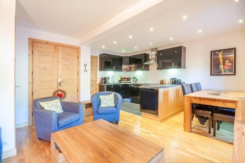 une cuisine et un salon avec une table et des chaises dans l'établissement Christiania 4, à Morzine