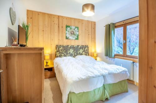 une chambre avec un lit et un mur en bois dans l'établissement Christiania 4, à Morzine