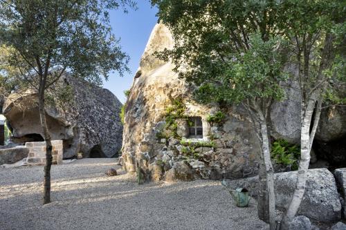 a stone house with a window in a rock wall at Gallicantu Stazzo Retreat in Luogosanto