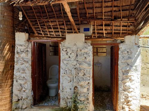 a bathroom with a toilet inside of a building at Fontaine Garden Village in Bwejuu