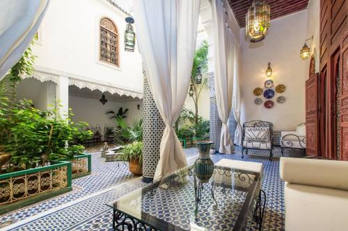 uma sala de estar com uma mesa de vidro numa casa em Riad Vega em Fez