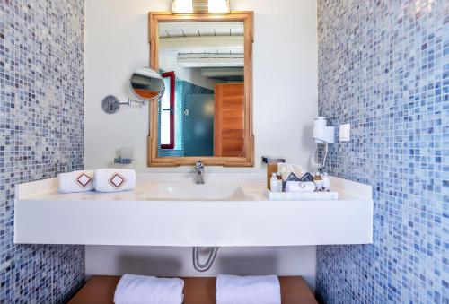 a bathroom with a white sink and a mirror at Varos Village Boutique Hotel in Város