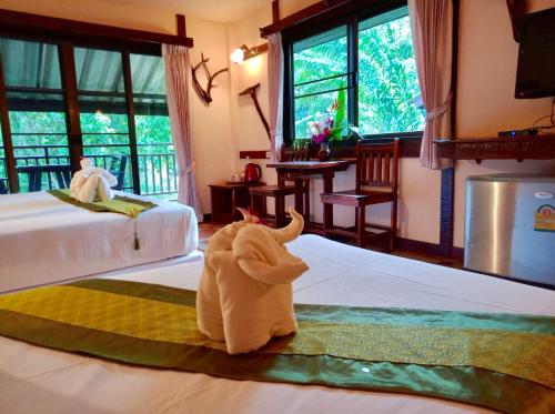 un animal de toallas sentado en una cama en un dormitorio en Khao Sok River Lodge Hotel, en Khao Sok