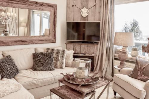 a living room with a white couch and a tv at HOME Suites Maisonette mit Sauna in Braunlage