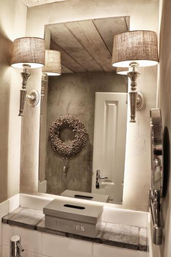a bathroom with two lights and a mirror at HOME Suites Maisonette mit Sauna in Braunlage