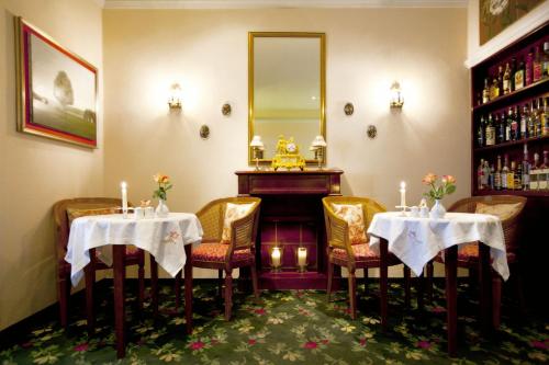 a dining room with two tables and a piano at Hotel Kurpfalzstuben in Mannheim