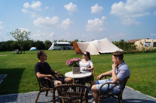 a group of people sitting at a table in a yard at Hoeve Linnerveld XL in Sint Odiliënberg