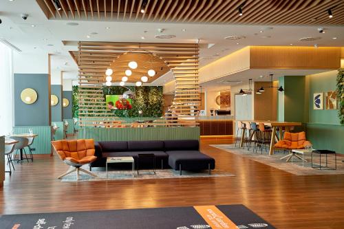 a living room filled with furniture and a large window at Sound Garden Hotel Airport in Warsaw