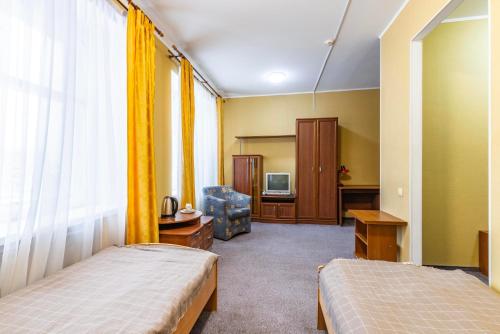 a hotel room with two beds and a television at Гостиница Большой Урал in Yekaterinburg