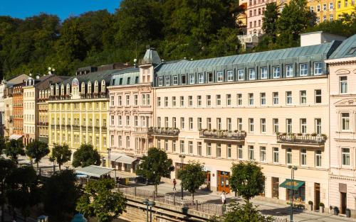 a large white building with a green roof at Hotel Kolonada in Karlovy Vary