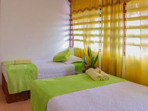 two beds in a room with green and white at Eco Hotel El Refugio Boutique in Leticia