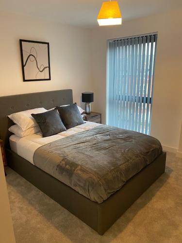 a bedroom with a large bed and a window at Icona - Stylish apartment in brand new development! in York