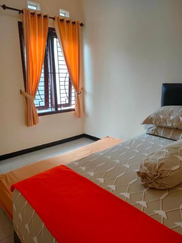 a bedroom with a large bed and a window at Villa Amadeo in Batu