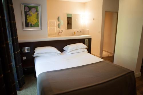 a bedroom with a bed and a large mirror at Hotel La Beauze in Aubusson