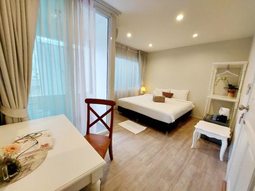 a hotel room with a bed and a table and a desk at Bliss Silom Bangkok in Bangkok