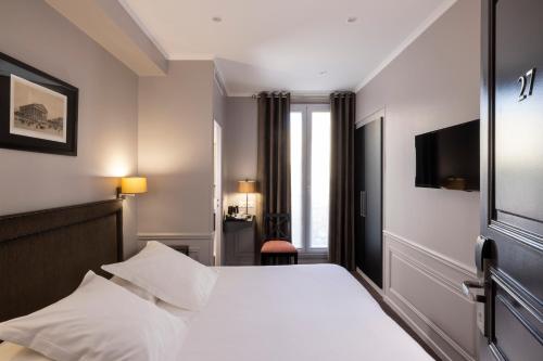 a hotel room with a bed and a television at Pavillon Monceau in Paris