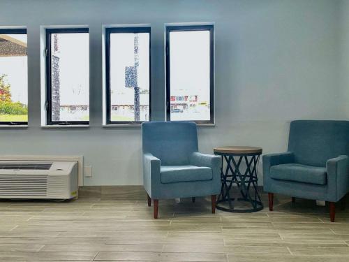 two chairs and a heater in a waiting room with windows at Lamoni Inn & Suites in Lamoni