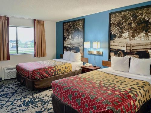 ein Hotelzimmer mit 2 Betten und einem Fenster in der Unterkunft Rodeway Inn near I-35 Lamoni in Lamoni