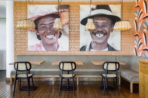 a bar with two portraits of two men at Radisson Hotel Tamboho Waterfront Antananarivo in Antananarivo
