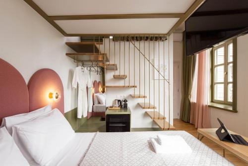 a bedroom with a white bed and a staircase at Neratze Hammam Suites in Rethymno Town