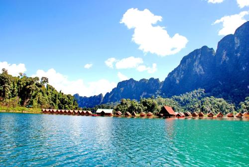 a large body of water with mountains in the background at Khao Sok River Lodge Hotel in Khao Sok