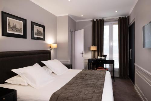 a hotel room with a bed and a desk at Pavillon Monceau in Paris