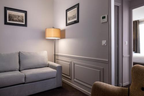a living room with a couch and a lamp at Pavillon Monceau in Paris