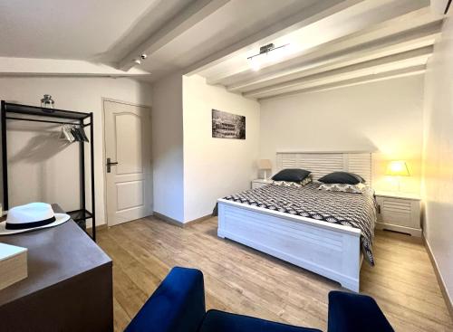 1 dormitorio con 1 cama y 1 silla azul en L'ALPILLE - Maison de vacances située à 10 mn à pied du centre ville de St Rémy avec place de parking privative en Saint-Rémy-de-Provence