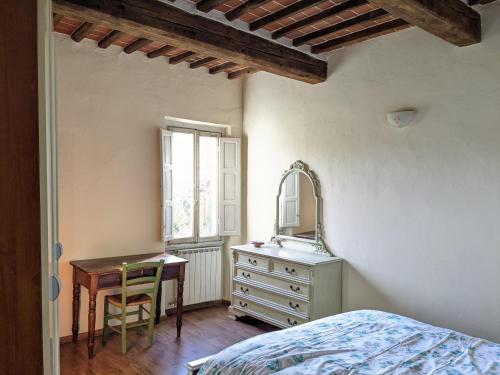 sypialnia z łóżkiem, biurkiem i lustrem w obiekcie Casa Baldecchi - Pistoia Centro Storico w mieście Pistoia