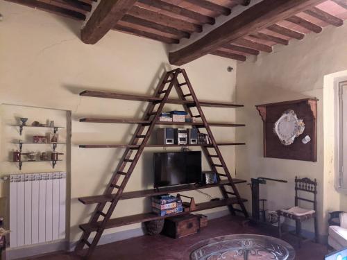 salon z drewnianą drabiną i telewizorem w obiekcie Casa Baldecchi - Pistoia Centro Storico w mieście Pistoia